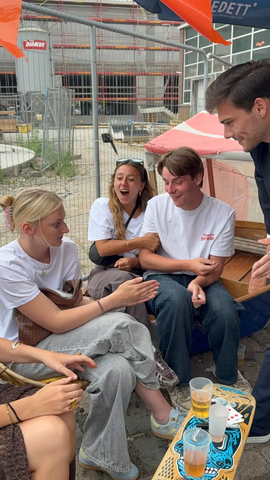 Jongeren reageren enthousiast op een kaarttruc op een terras