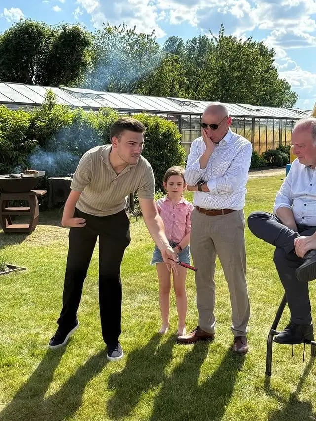 Wout entertaint gasten met magie tijdens een buitenfeest